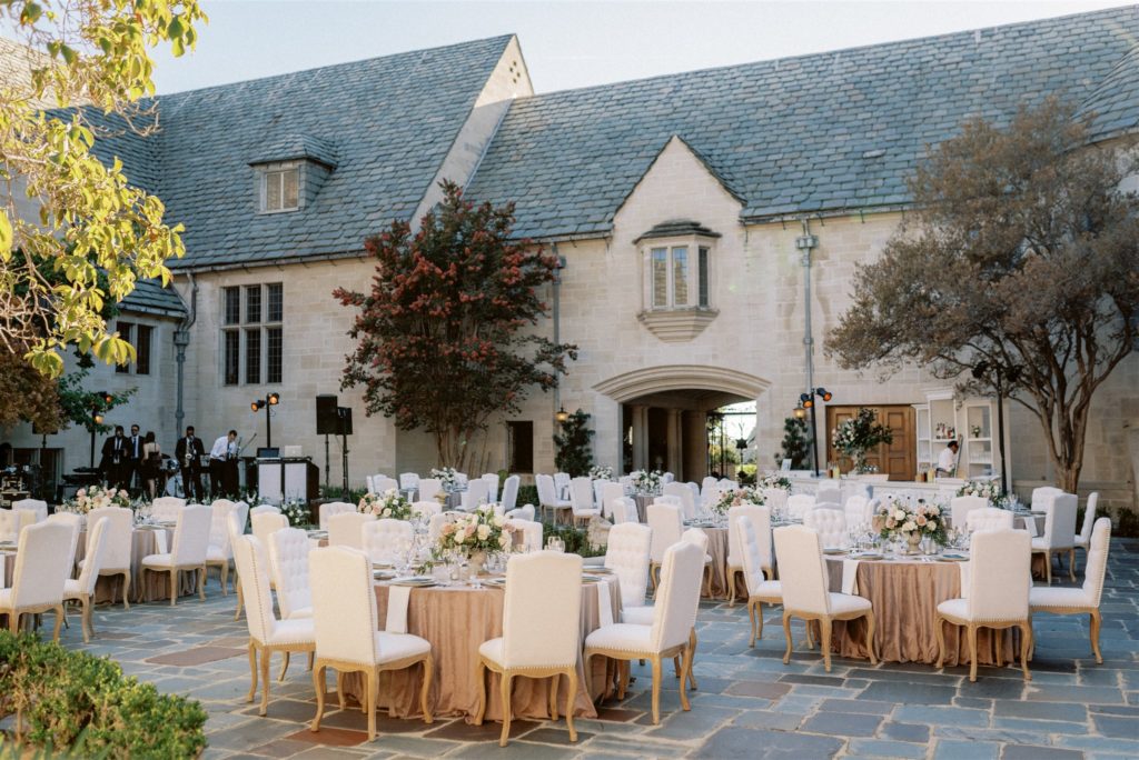 Greystone Mansion courtyard wedding Reception - Round tables with mauve velvet linens and white tufted chairs
