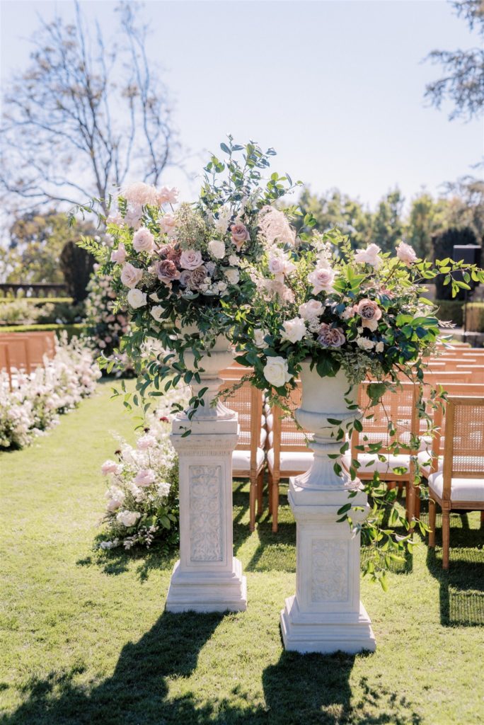 classic garden style stone urns and pedestals with blush and mauve romantic florals 