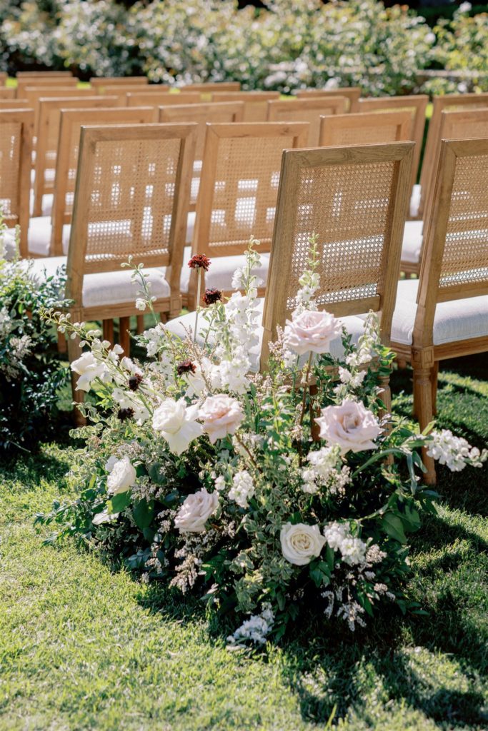 Natural style aisle arrangements ground florals with blush and white roses
